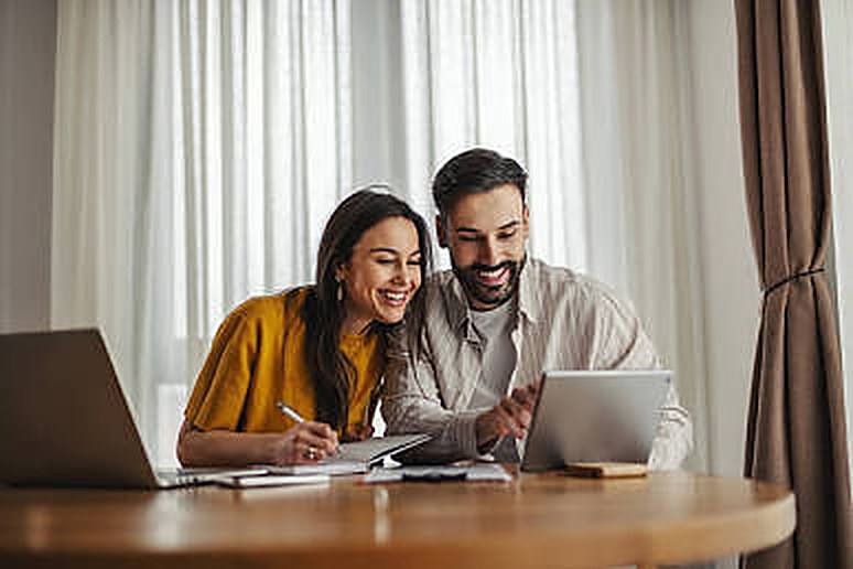 A couple smiling while reviewing paperwork together