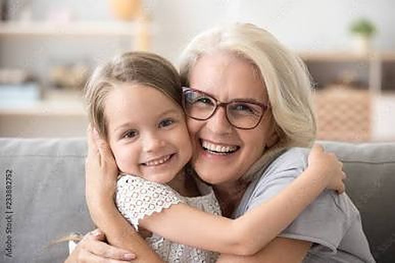 A grandmother hugging a smiling child
